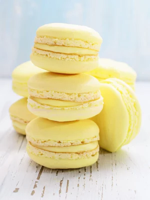 Yellow macaroons on white wooden background